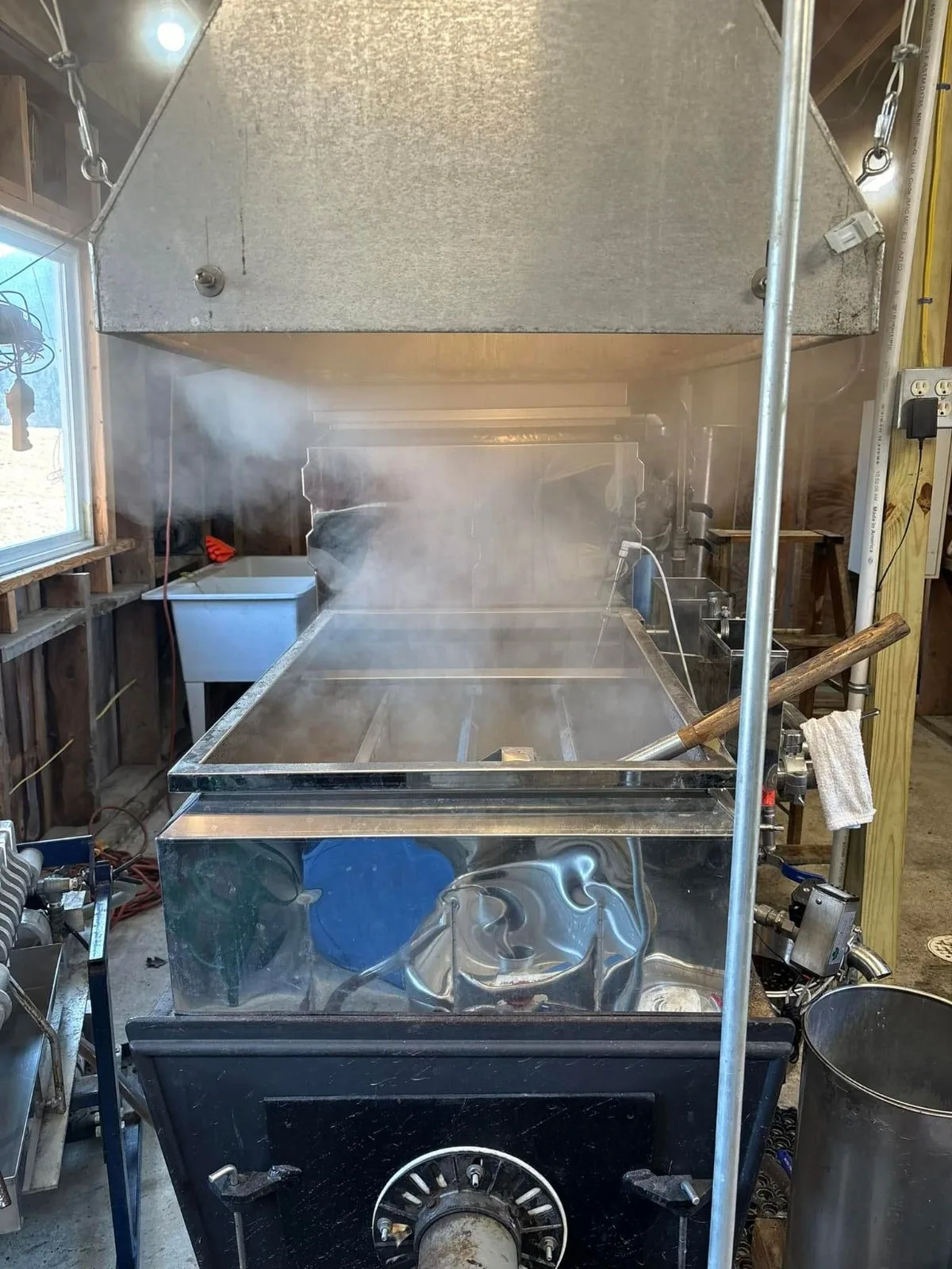 Steam rising from the evaporator pan inside the sugarhouse